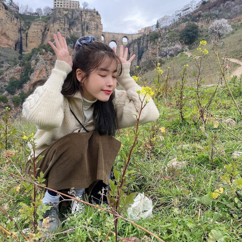 IU poses in front of the Puente Nuevo bridge, sharing her vacation