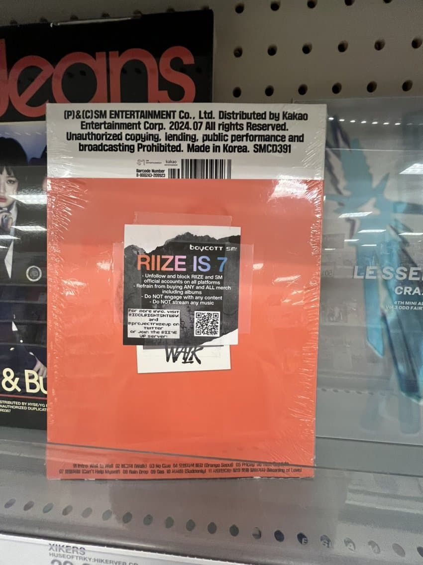 Seunghan fans are putting 'RIIZE is 7' boycott stickers on RIIZE merchandise at stores